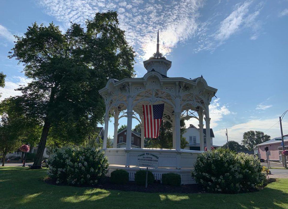 Bellville, OH - Gazebo with American Flag in Downtown Bellville Ohio Surrounded by Flowering Bushes on a Sunny Day